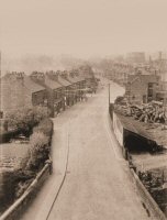 A photograph of Pye Bridge taken from the railway viaduct. The Gas Holders from the Gas Works can be seen at the top right. Bunting has been strung across the street, although the date and occasion are not known.
