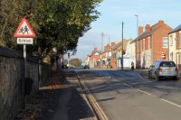 Nottingham Road, Somercotes. The photograph is taken from the Church of St. Thomas. The wall of the church is on the left of the photograph. Taken in 2012.