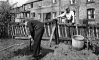 This photograph shows Charlie Smith (standing, right) at his house at Pennytown.