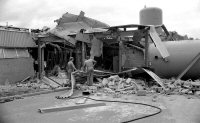 Worker inspecting the results of a fire at the Plyglass factory on the Cotes Park Industrial Estate. Ripley & Heanor photograph date unknown.